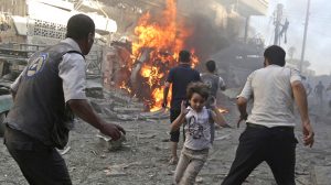 A boy runs as he rushes away from a site hit by what activists said were airstrikes by forces loyal to Syria's President Bashar al-Assad in the Douma neighborhood of Damascus, Syria August 24, 2015. REUTERS/Bassam Khabieh - RTS6T7U