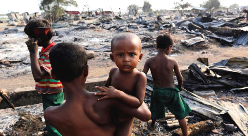 Boys stand among debris after fire destroyed shelters at a camp for internally displaced Rohingya Muslims in the western Rakhine State near Sittwe, Myanmar May 3, 2016. REUTERS/Soe Zeya Tun - RTX2CMC2
