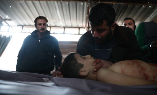 A father mourns over the body of his 11-year-old son, Ahmad, who was reportedly killed along with a friend when a cluster bomb exploded in his backyard, at a makeshift morgue in the rebel-held town of Douma, on the eastern outskirts of the capital Damascus, on January 6, 2017. / AFP PHOTO / Abd Doumany